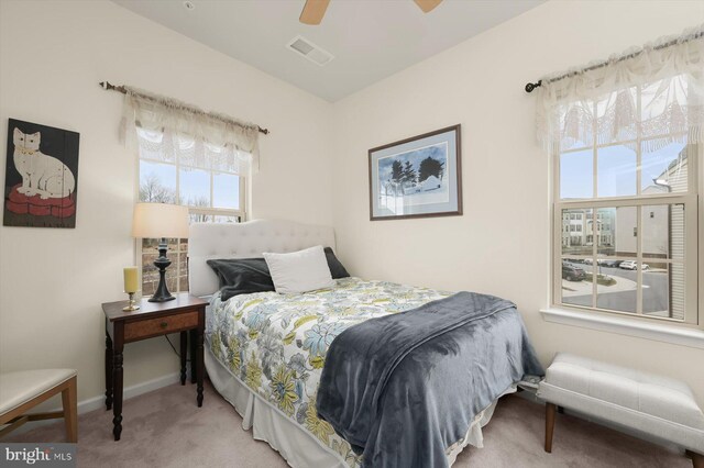 carpeted bedroom with baseboards, visible vents, and ceiling fan