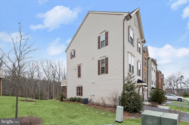 view of home's exterior with central AC and a lawn