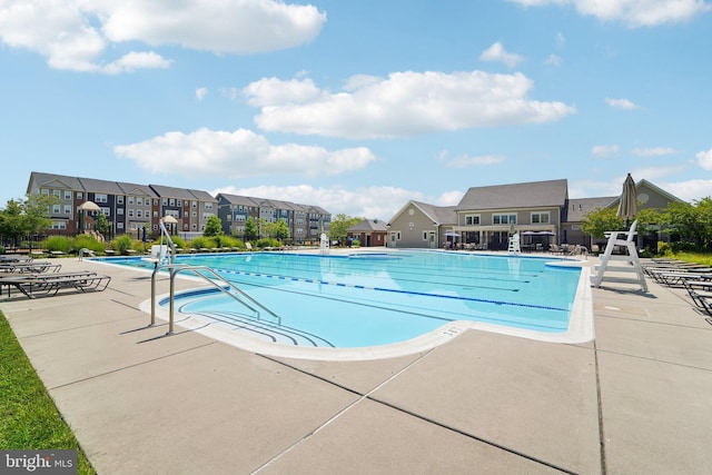 pool with a residential view and a patio