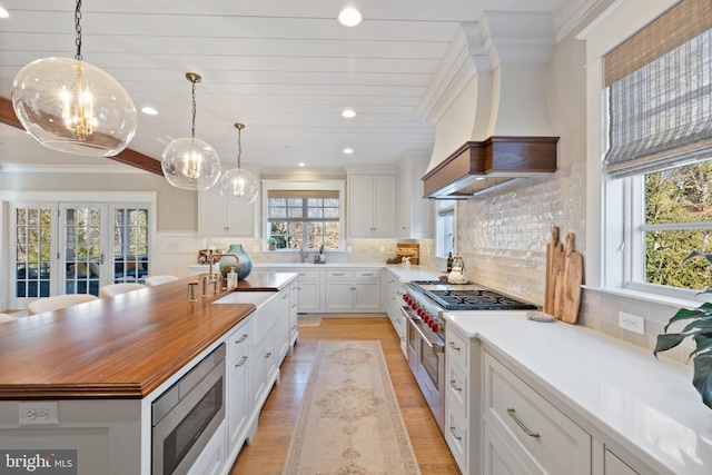 kitchen with white cabinetry, stainless steel appliances, a center island, and pendant lighting