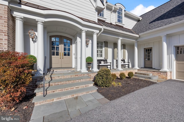 view of exterior entry featuring french doors and a porch