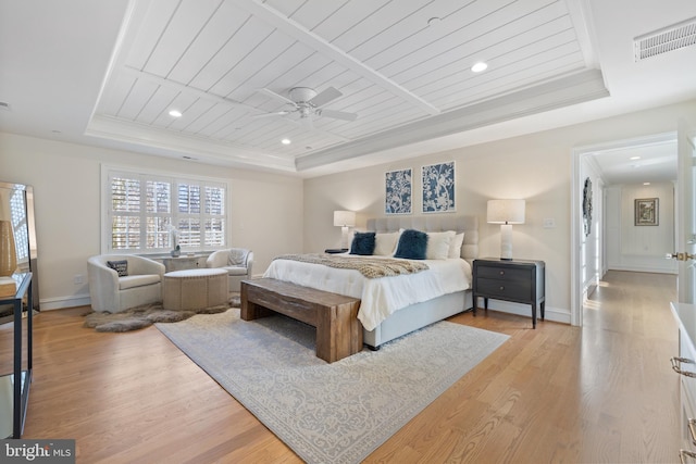 bedroom with ceiling fan, ornamental molding, light hardwood / wood-style floors, wooden ceiling, and a raised ceiling