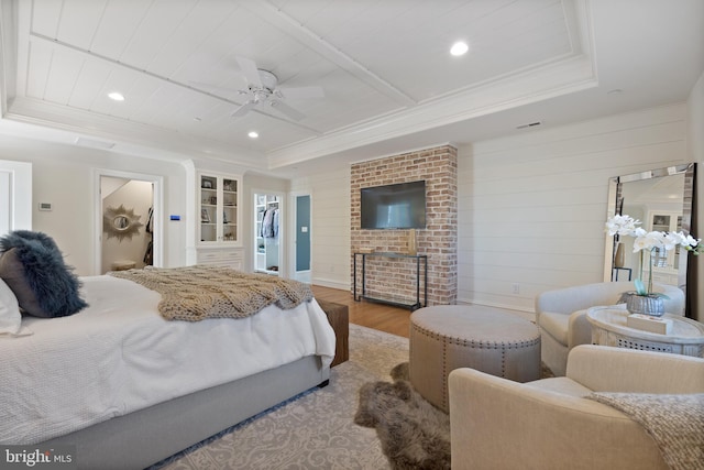 bedroom with hardwood / wood-style flooring, ornamental molding, and a raised ceiling