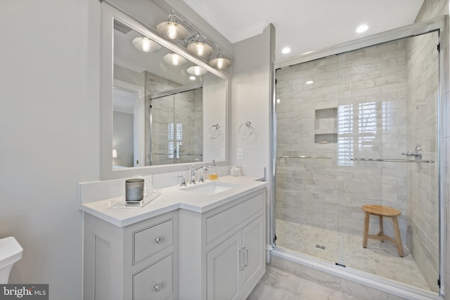 bathroom with a shower with door and vanity