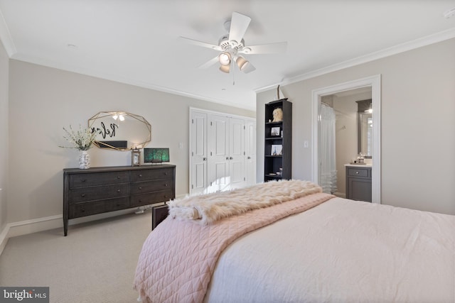 bedroom with crown molding, ceiling fan, ensuite bathroom, light carpet, and a closet