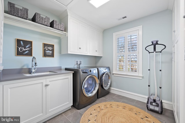 laundry area featuring cabinets, washing machine and dryer, sink, and tile patterned floors