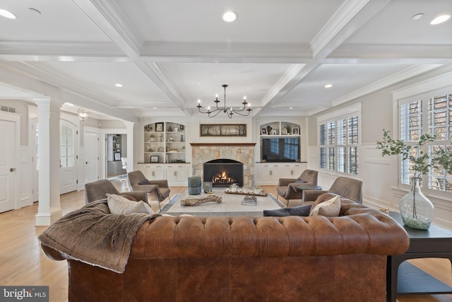 living room with coffered ceiling, built in shelves, beam ceiling, and ornate columns