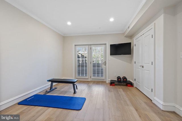 exercise room with hardwood / wood-style floors and ornamental molding