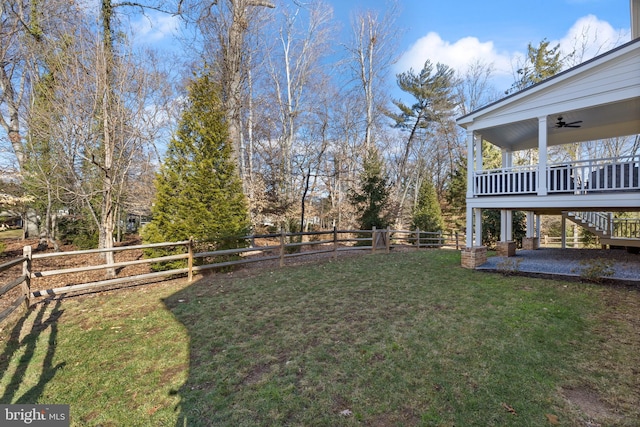 view of yard featuring ceiling fan and a deck