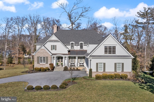 view of front of home featuring a balcony, covered porch, and a front lawn