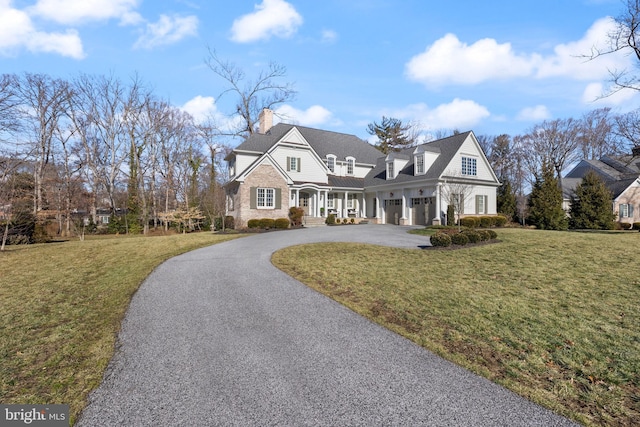 new england style home with a garage and a front yard