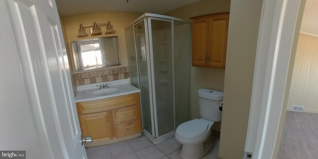 bathroom featuring tile patterned flooring, vanity, an enclosed shower, and toilet