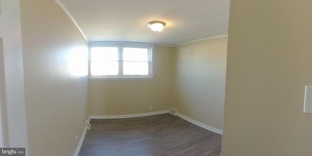 empty room with ornamental molding and dark hardwood / wood-style flooring