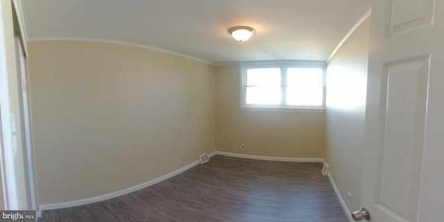 empty room with dark hardwood / wood-style flooring and ornamental molding