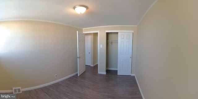 unfurnished bedroom featuring a closet, ornamental molding, and dark hardwood / wood-style floors