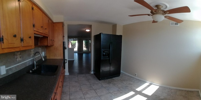 kitchen featuring sink, light tile patterned floors, ceiling fan, tasteful backsplash, and black refrigerator with ice dispenser