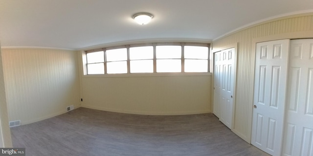 interior space featuring multiple closets, crown molding, and hardwood / wood-style flooring