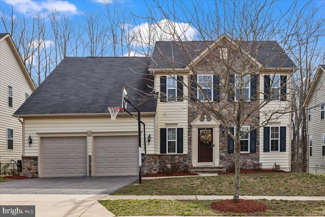 colonial house with stone siding, an attached garage, roof with shingles, and driveway