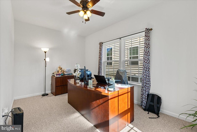 home office with a ceiling fan, light colored carpet, and baseboards