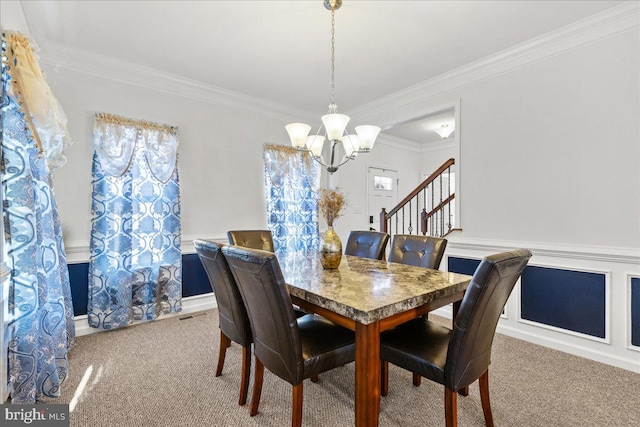 dining space featuring stairs, a notable chandelier, carpet flooring, and crown molding