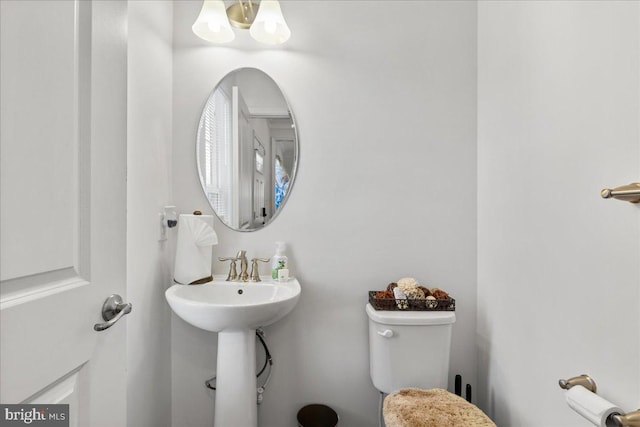 bathroom featuring toilet and a chandelier