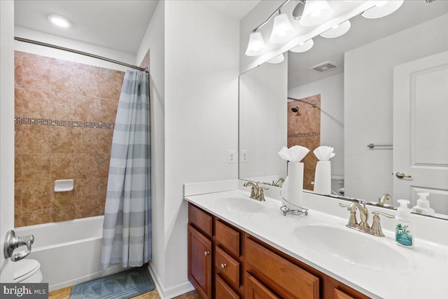 bathroom featuring visible vents, toilet, shower / bath combo, and a sink