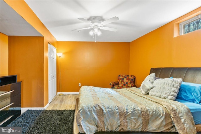 bedroom with wood finished floors, baseboards, and ceiling fan