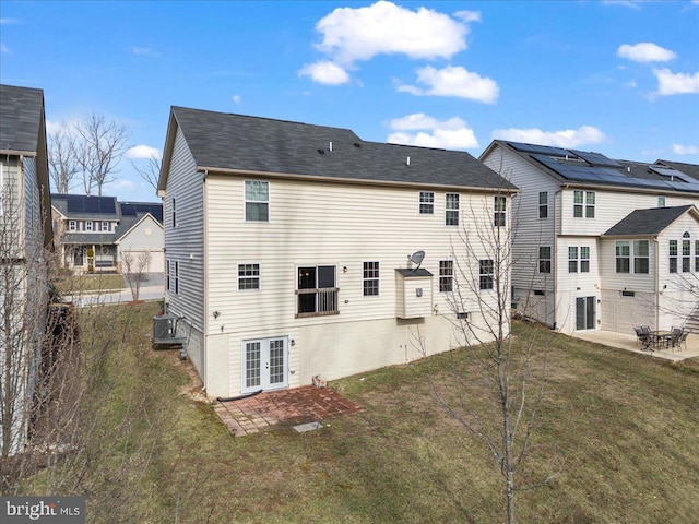 back of property with french doors, a patio, and a yard