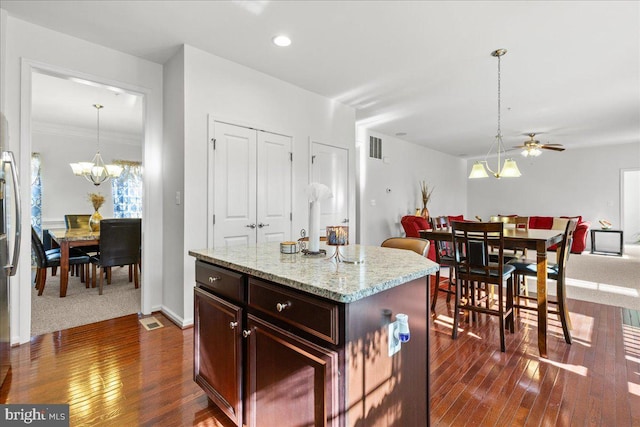 kitchen with a notable chandelier, open floor plan, dark wood finished floors, and hanging light fixtures