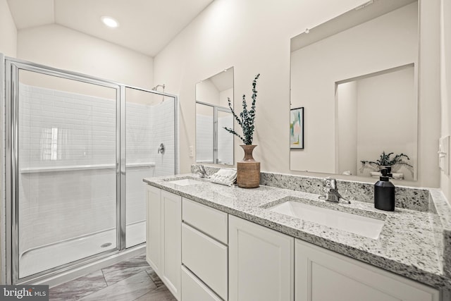 bathroom with walk in shower, vanity, and vaulted ceiling