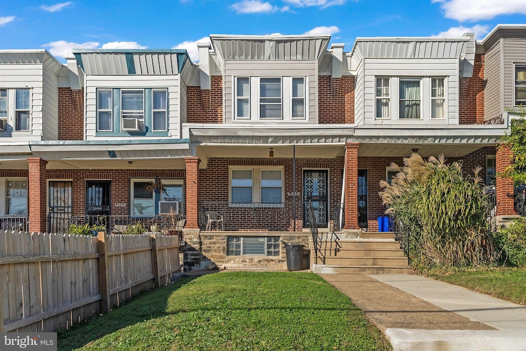 townhome / multi-family property with a front yard and cooling unit