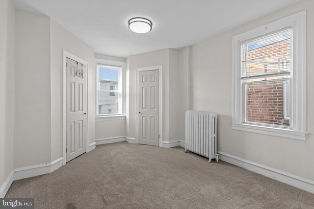 carpeted empty room featuring radiator