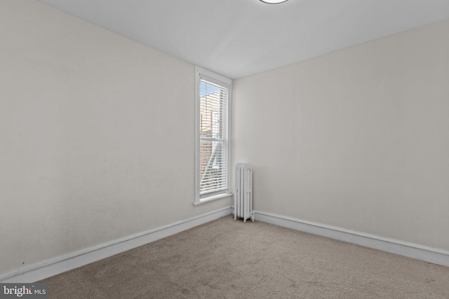 carpeted spare room with radiator heating unit