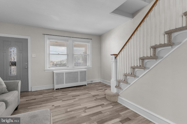 foyer entrance featuring light hardwood / wood-style flooring and radiator heating unit