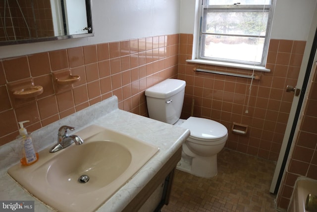 bathroom featuring vanity, toilet, and tile walls