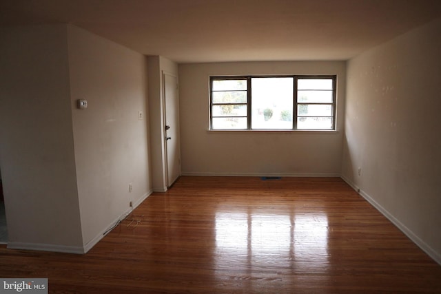 unfurnished room with dark wood-type flooring