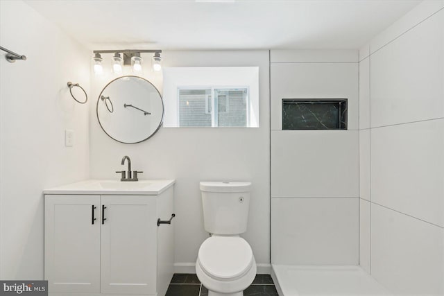 bathroom with vanity, a shower, and toilet