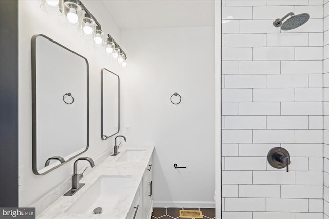 bathroom with tile patterned flooring, vanity, and tiled shower