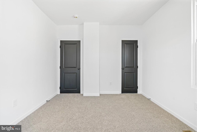 unfurnished room featuring light carpet