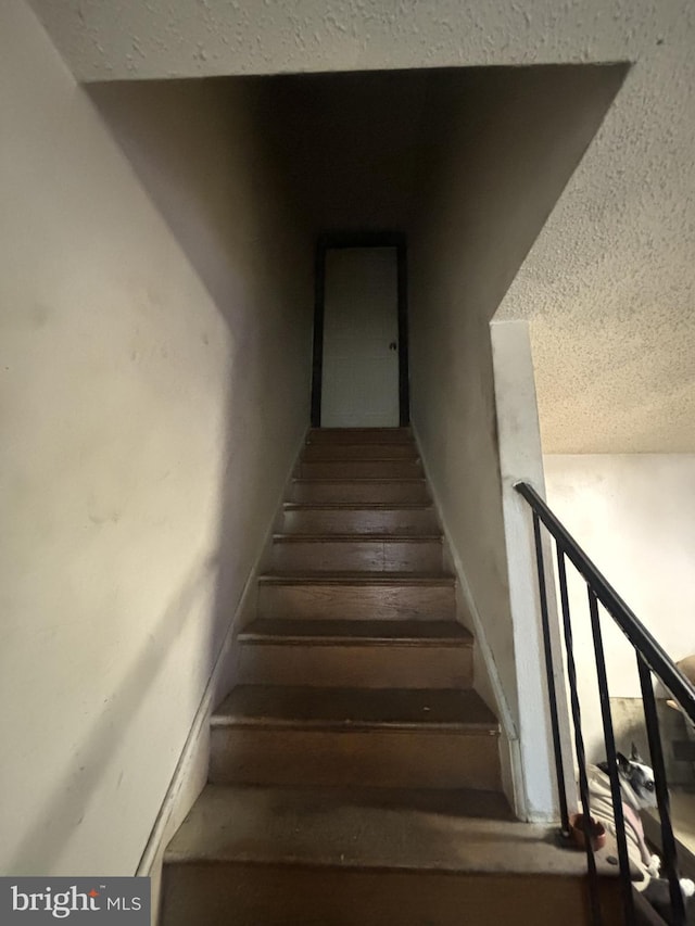 staircase with a textured ceiling