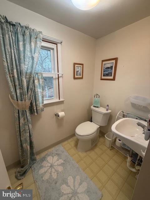 bathroom featuring baseboards and toilet