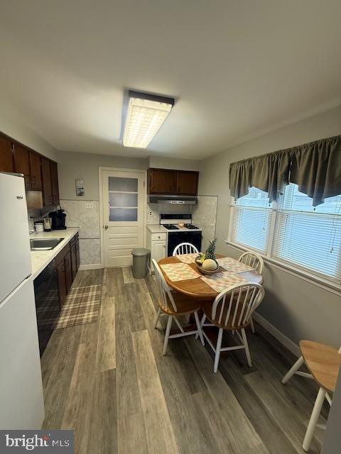 dining room featuring baseboards, wood finished floors, and wainscoting