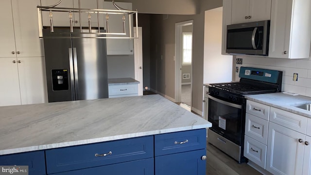 kitchen featuring blue cabinetry, white cabinetry, tasteful backsplash, pendant lighting, and stainless steel appliances