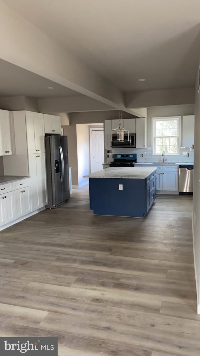 kitchen with blue cabinets, stainless steel appliances, white cabinets, and a kitchen island