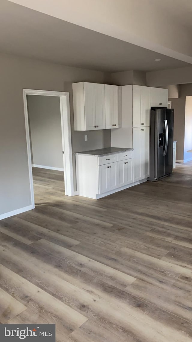 kitchen featuring white cabinetry, stainless steel refrigerator with ice dispenser, and light wood-type flooring