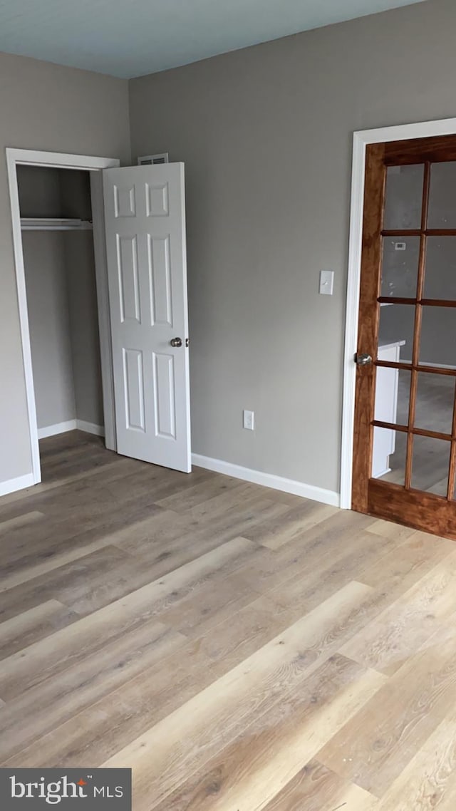 unfurnished bedroom featuring a closet and light wood-type flooring