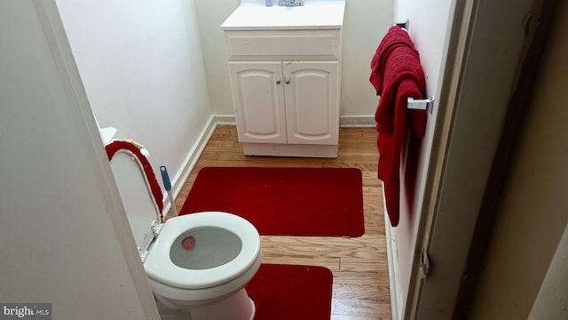 bathroom featuring hardwood / wood-style flooring, toilet, and sink