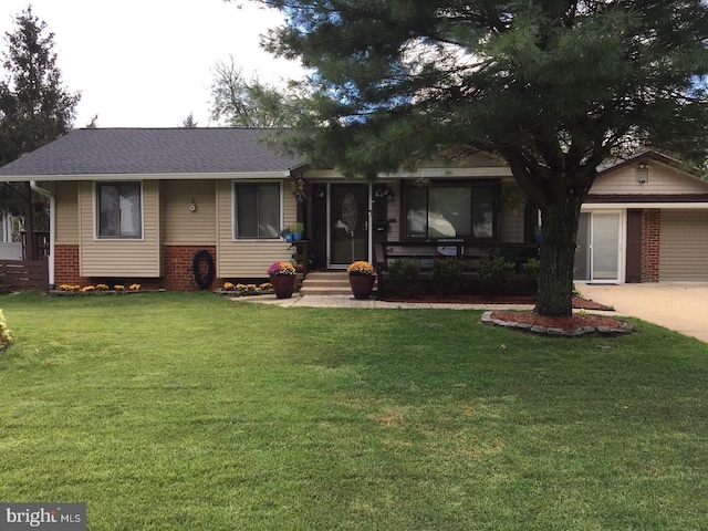 ranch-style home featuring a garage and a front yard