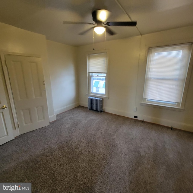 empty room featuring carpet flooring, radiator heating unit, and ceiling fan