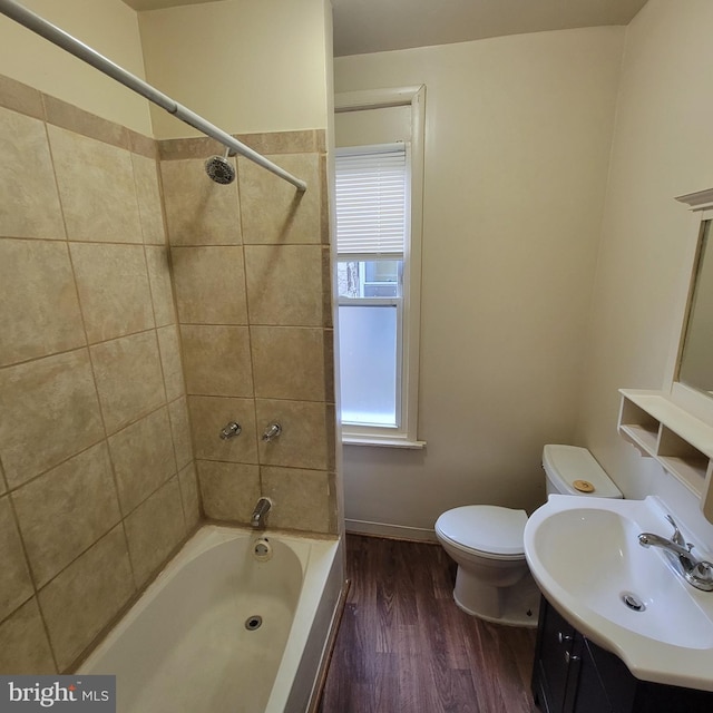 full bathroom with vanity, wood-type flooring, toilet, and tiled shower / bath